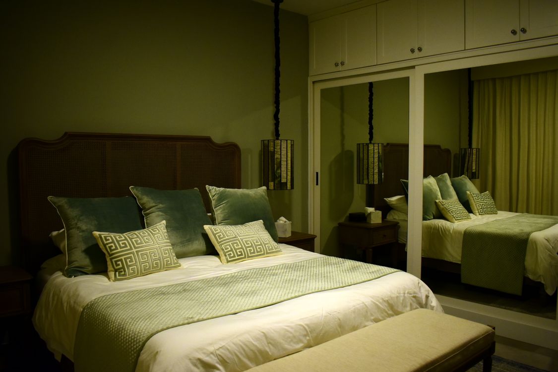 Bedroom with blackout curtains and a small fan showing a cool, dark, and quiet sleep setup
