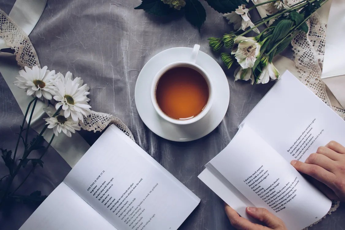 Mug of warm water beside a book on a side table in calm evening light
