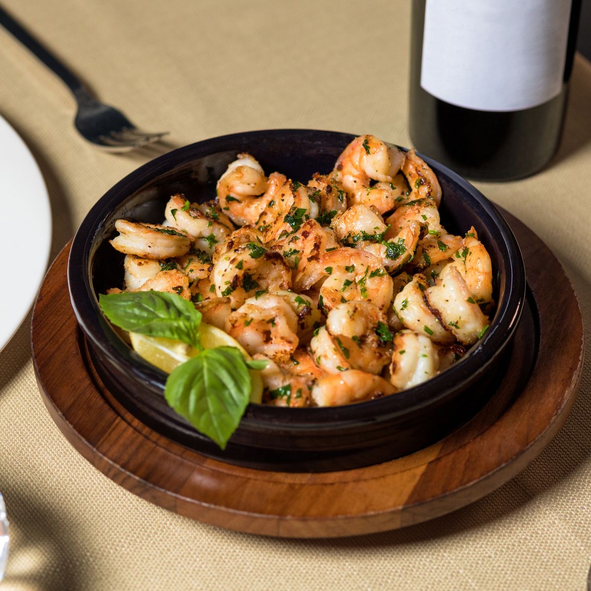 Garlic shrimp in a ceramic dish with lemon and herbs, a low calorie high protein food