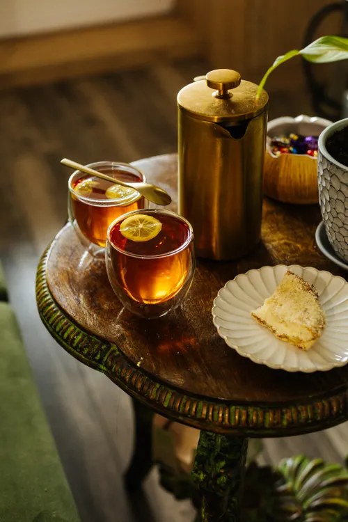 Glass mug of warm water with gentle steam and a lemon slice on a bright kitchen table
