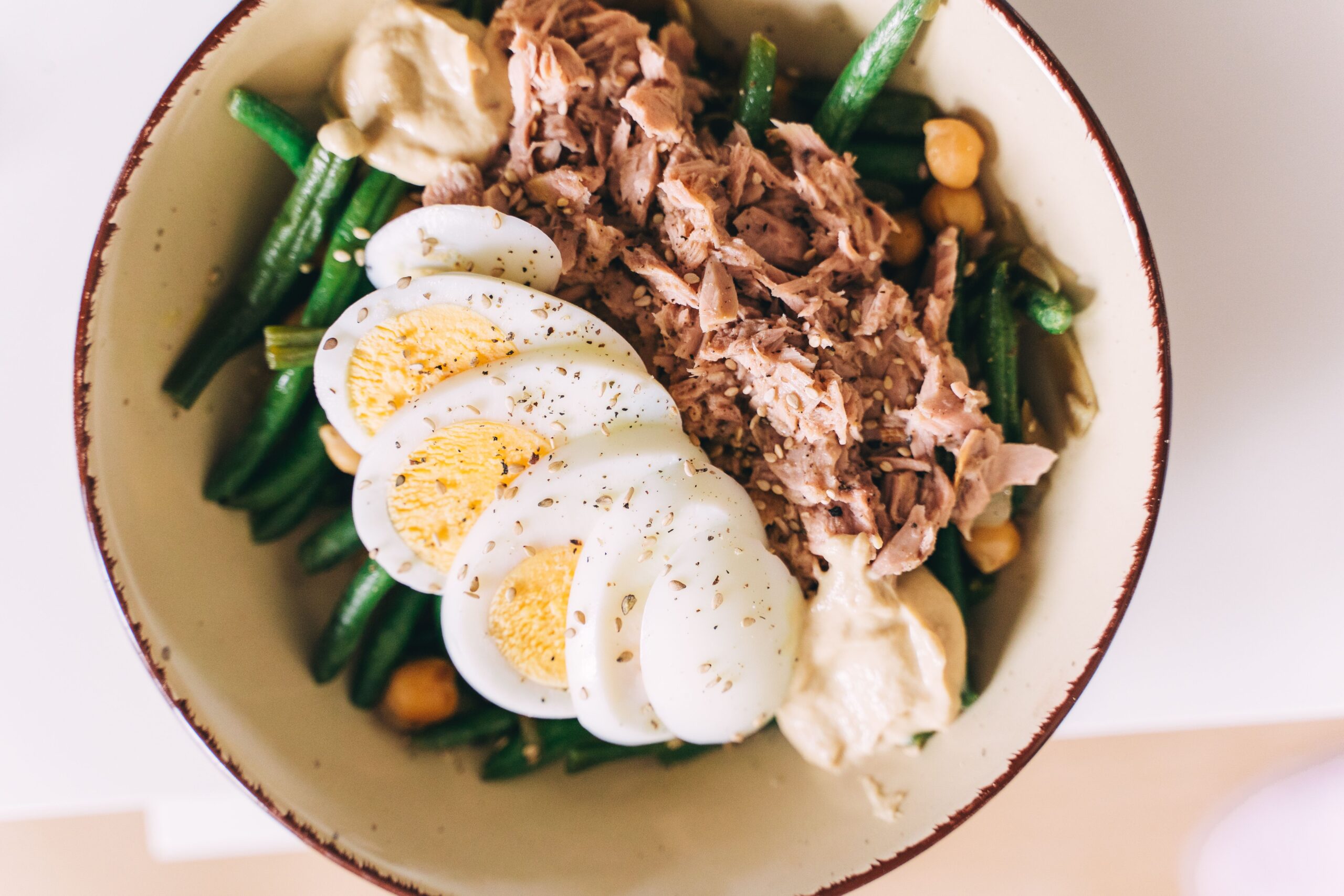 Tuna and green beans with egg salad in a ceramic bowl