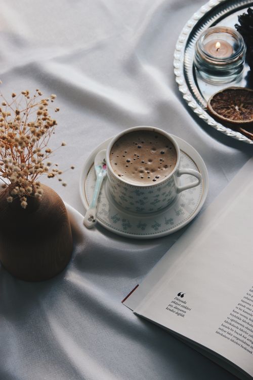 Warm caffeine-free drink and a paper book on a nightstand as part of a calm evening routine